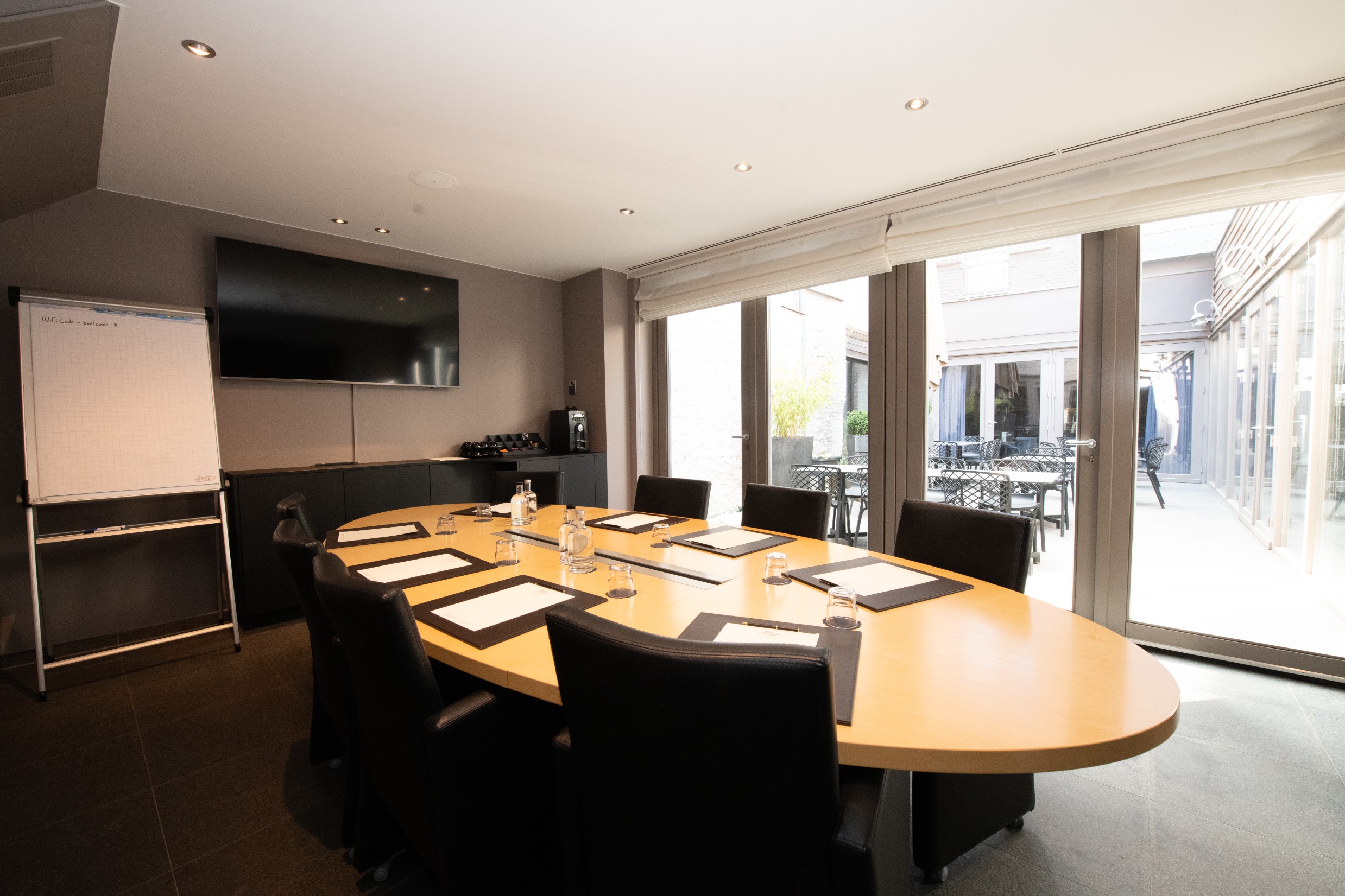 Vergaderzaal met houten tafel en presentatiescherm